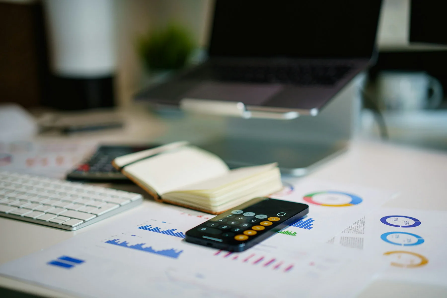 Financial reports, a calculator and a laptop on an accountant’s desk